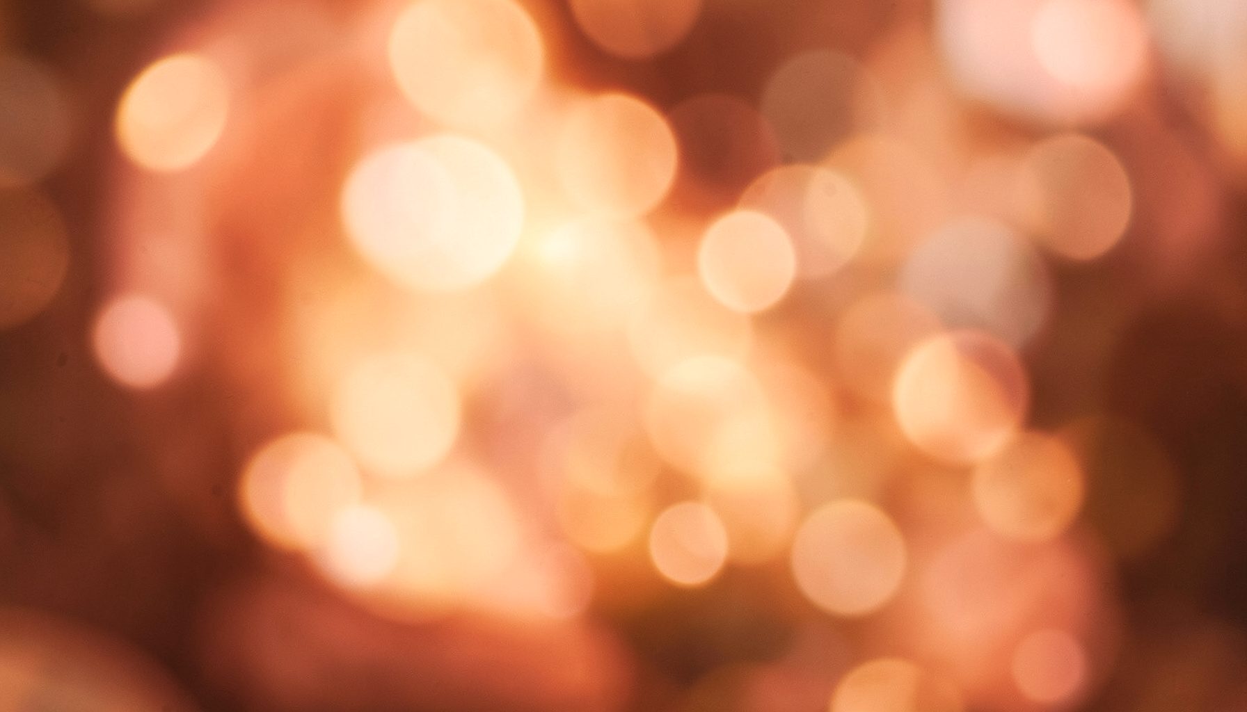 Warm amber and rose tones with soft bokeh circles, cozy and inviting atmosphere