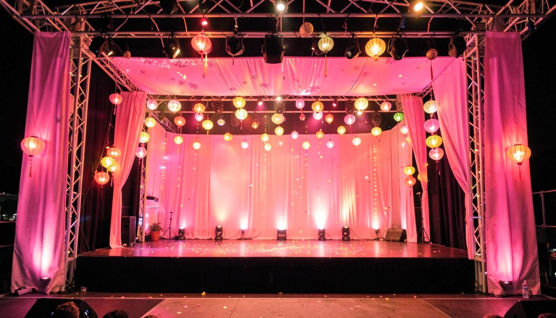 Festival-themed stage with pink banners and glowing lanterns, celebratory and warm mood